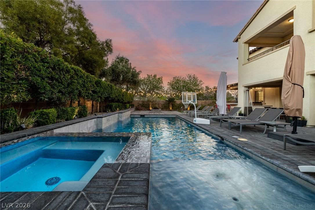 Image 3: An inviting backyard oasis offers a sparkling pool