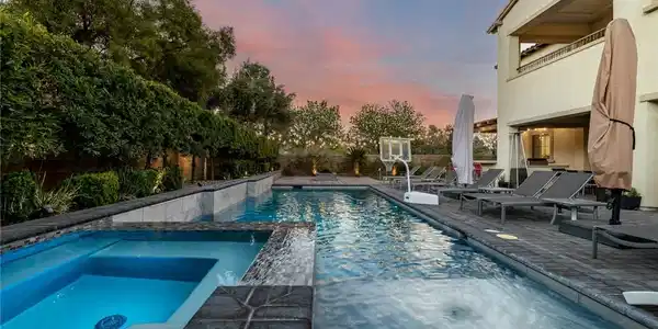 Image 3: An inviting backyard oasis offers a sparkling pool