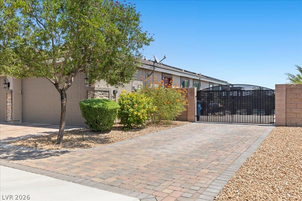 Image 3: A secure, brick-paved driveway leads to a two-car
