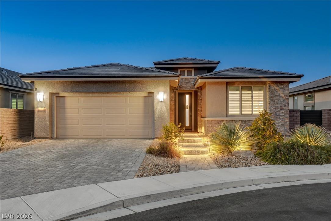 Image 1: A welcoming paver driveway leads to this modern ho