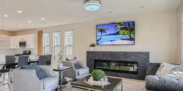 Image 2: An open living area features a modern stone firepl