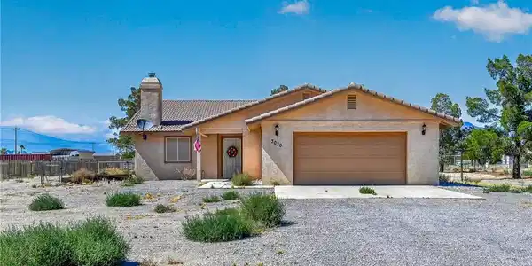 Image 2: A well-maintained facade with an attached garage a