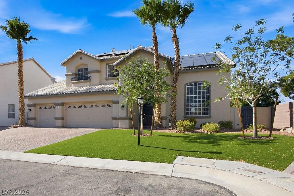 Image 3: A cream-colored stucco residence featuring a two-c
