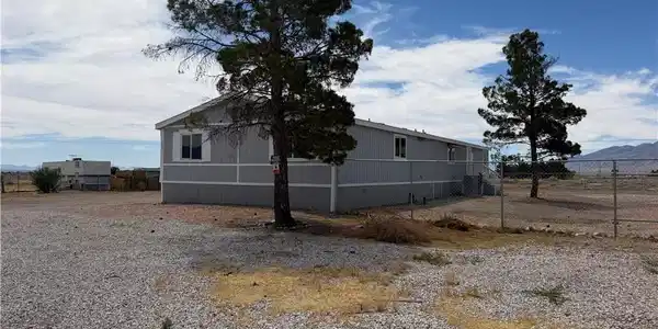 Image 4: A manufactured home with a gravel yard, offering o