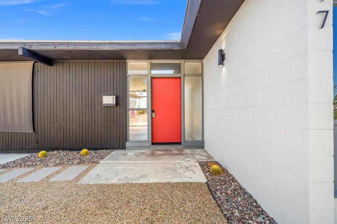 Image 2: A vibrant orange door provides a striking focal po