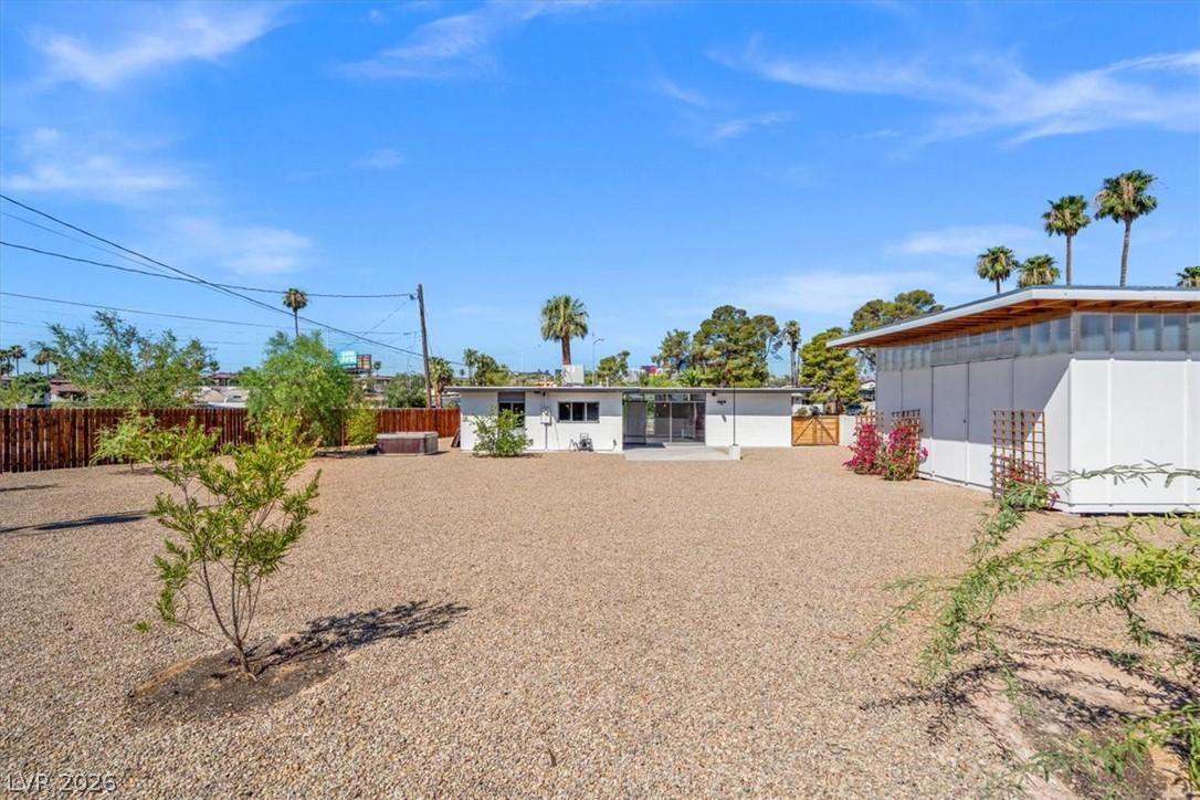 Image 4: A spacious backyard with gravel landscaping and am