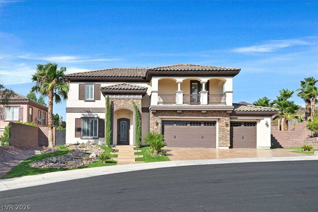 Image 2: Front of home with grand entry, stone-accented ext