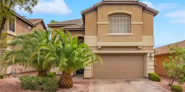 Image 3: Lush palm trees frame this contemporary stucco ext