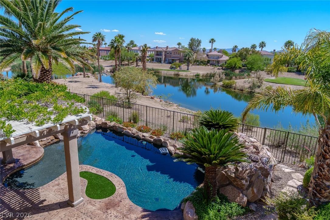 Image 2: View of pool with fence and a water view
