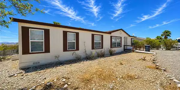 Image 3: A well-maintained manufactured home sits under a c