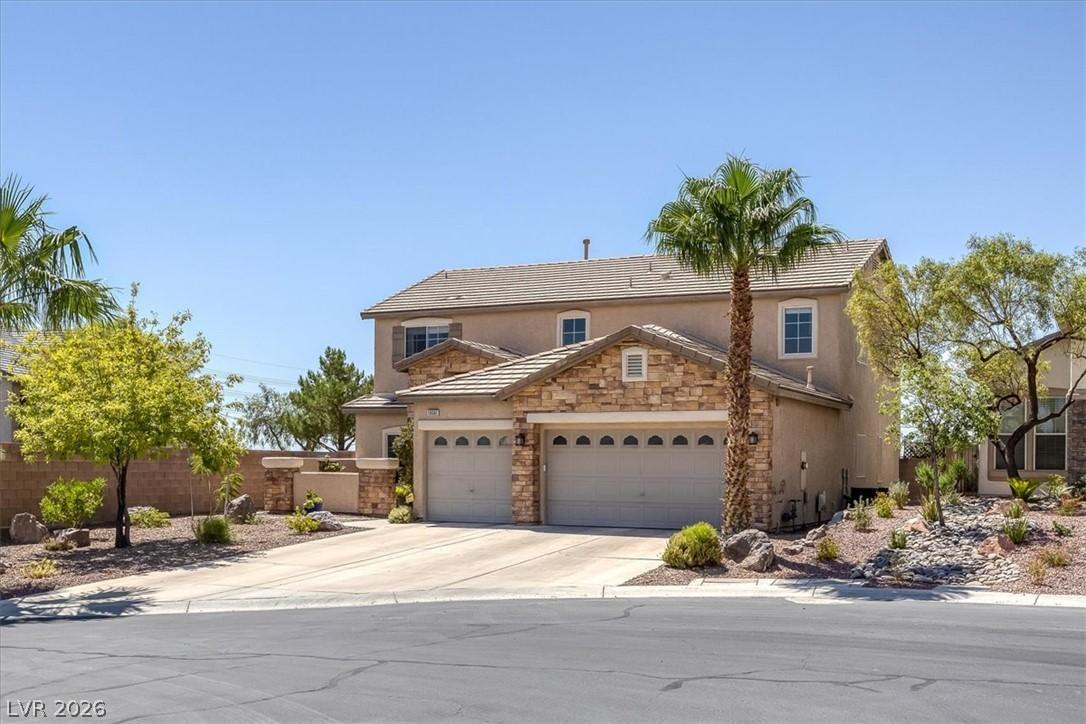 Image 2: A charming stucco home with stone accents, a tile