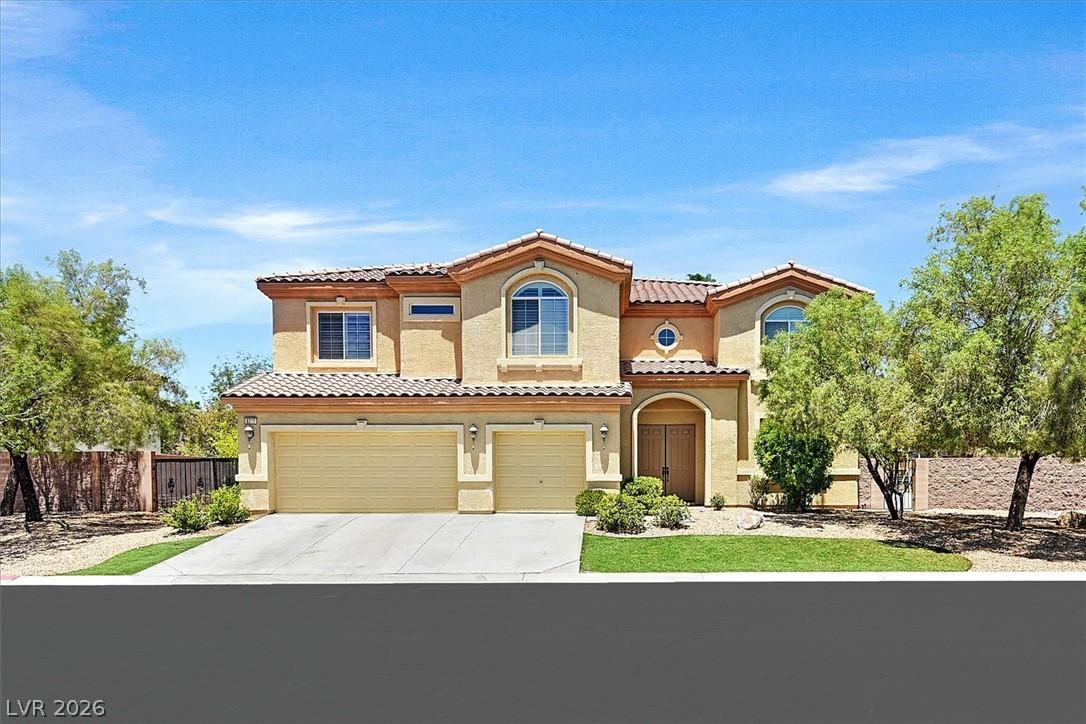 Image 1: A two-story stucco home with a tile roof and attac
