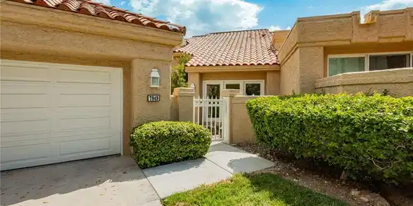 Image 2: A well-maintained stucco exterior with a tile roof