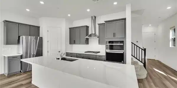 Image 2: Modern countertops and handsome cabinetry define t