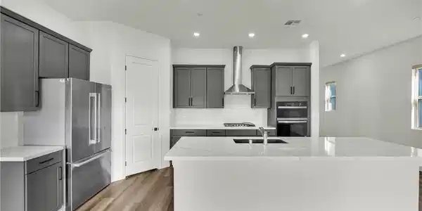 Image 4: Clean lines and smooth stone countertops define th