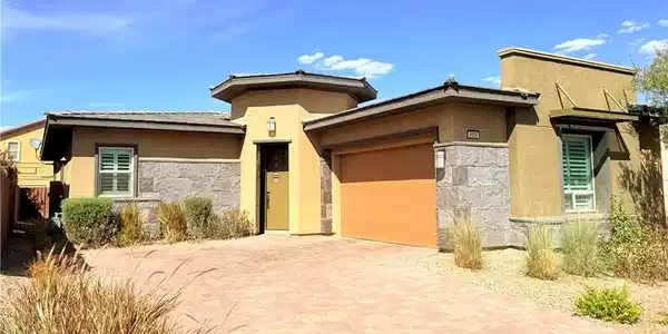 Image 2: A spacious brick paver driveway leads to this mode