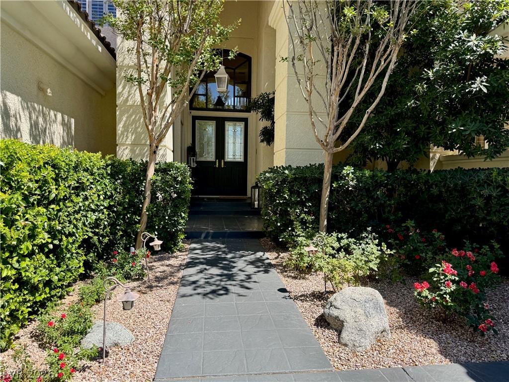 Image 2: An inviting courtyard entry is framed by meticulou