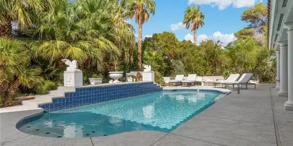 Image 3: Lush tropical palms and structured concrete deckin