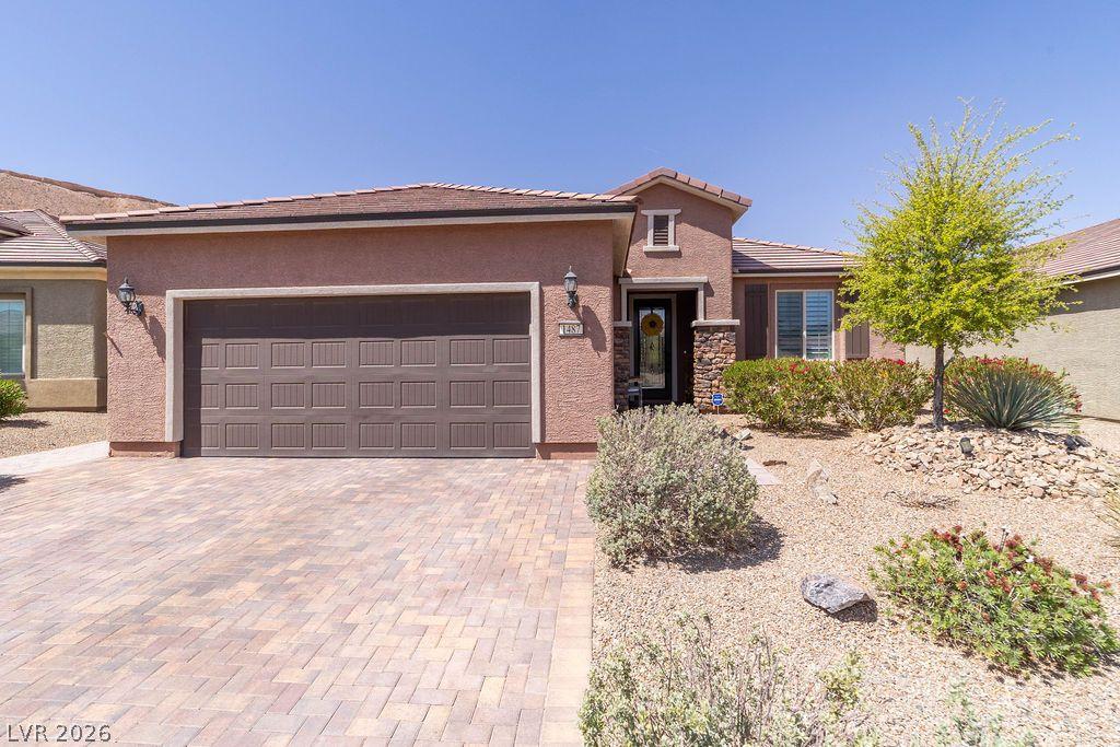 Image 1: A well-maintained stucco home with a paver drivewa