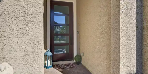Image 4: An inviting entryway features textured stucco wall