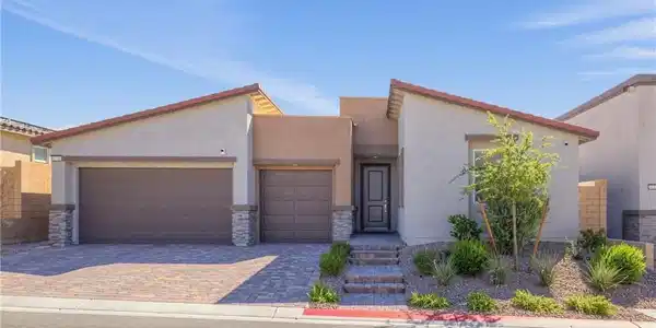 Image 2: A stone-accented facade and paver driveway create