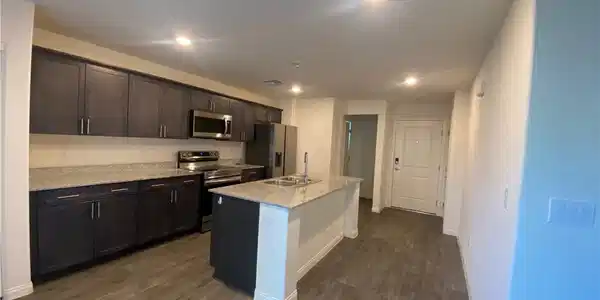 Image 3: A contemporary kitchen features dark cabinetry, gr