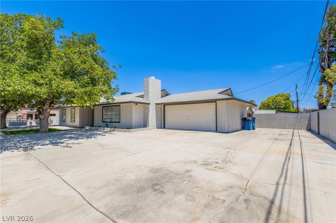 Image 2: A spacious concrete driveway leads to a single-sto
