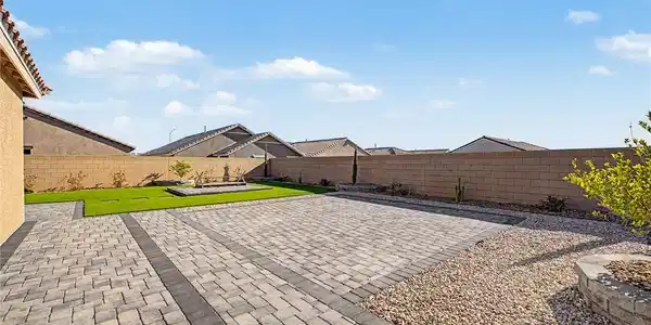 Image 2: A neatly paved patio extends to a vibrant green la