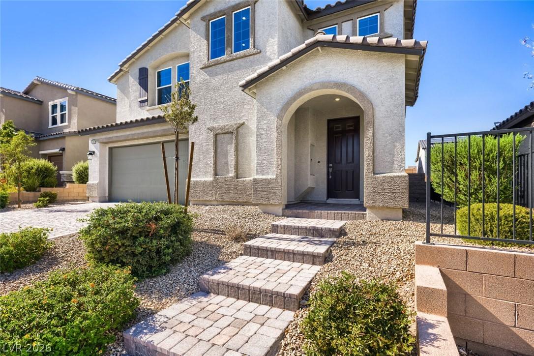 Image 2: A paver walkway amid desert landscaping to an arch