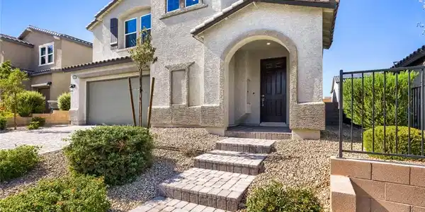 Image 2: A paver walkway amid desert landscaping to an arch