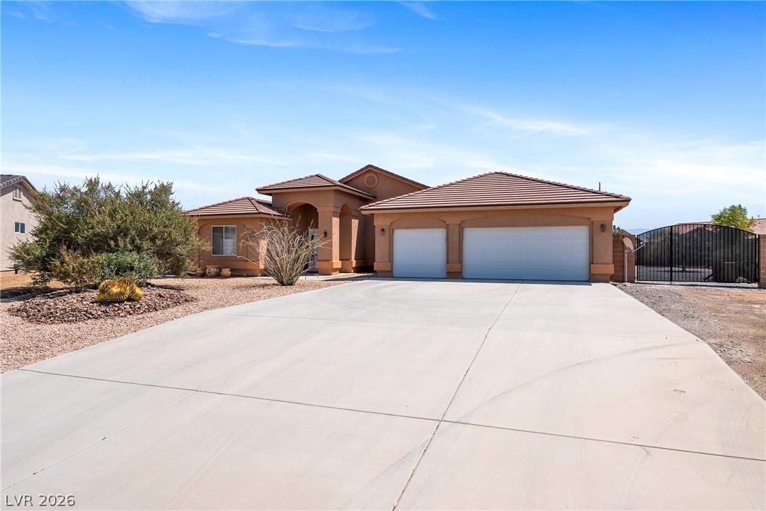 Image 2: A spacious driveway welcomes you to this desert oa