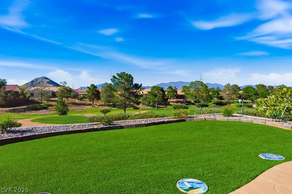 Image 1: A private putting green overlooks a scenic golf co