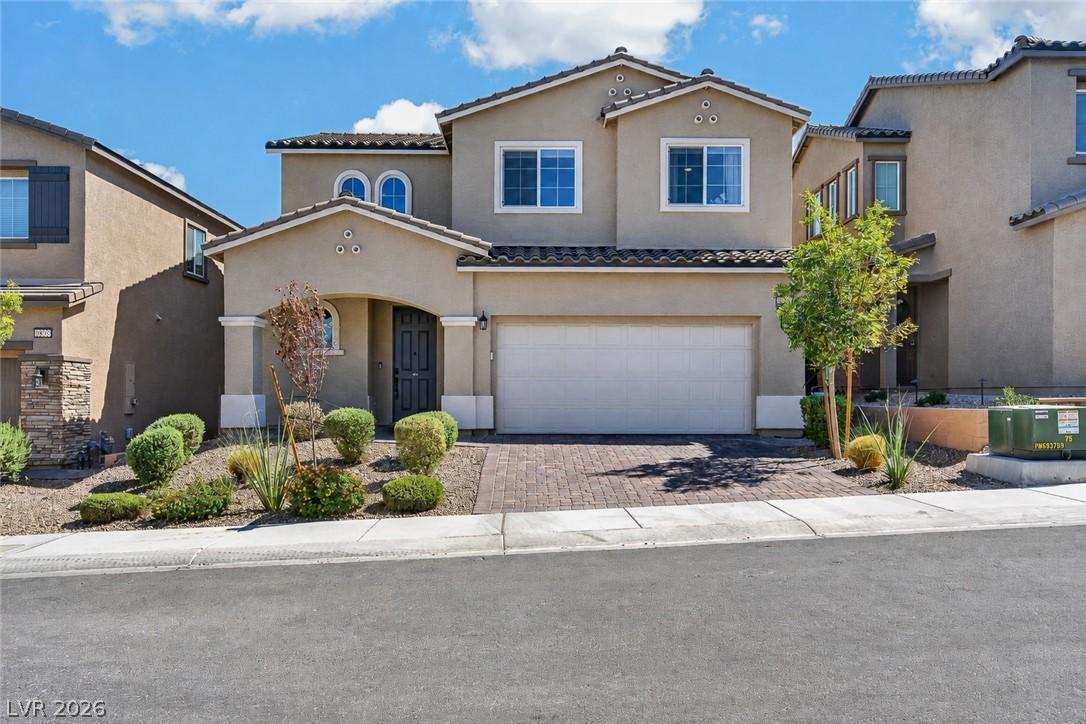 Image 3: A well-kept facade showcases a paver driveway and