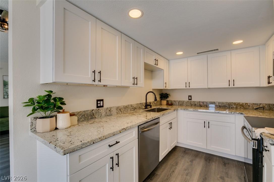 Image 4: Granite counters and white cabinetry define this w