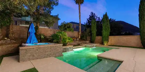 Image 2: An illuminated backyard oasis awaits, featuring a
