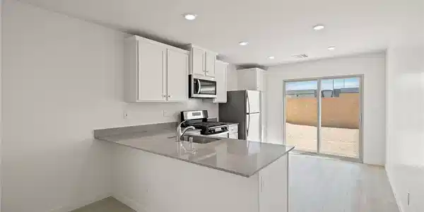 Image 4: Smooth countertops and crisp cabinetry anchor this