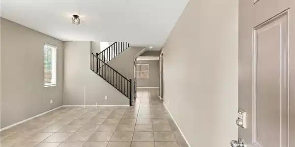 Image 3: An inviting entryway leads into a tiled living are