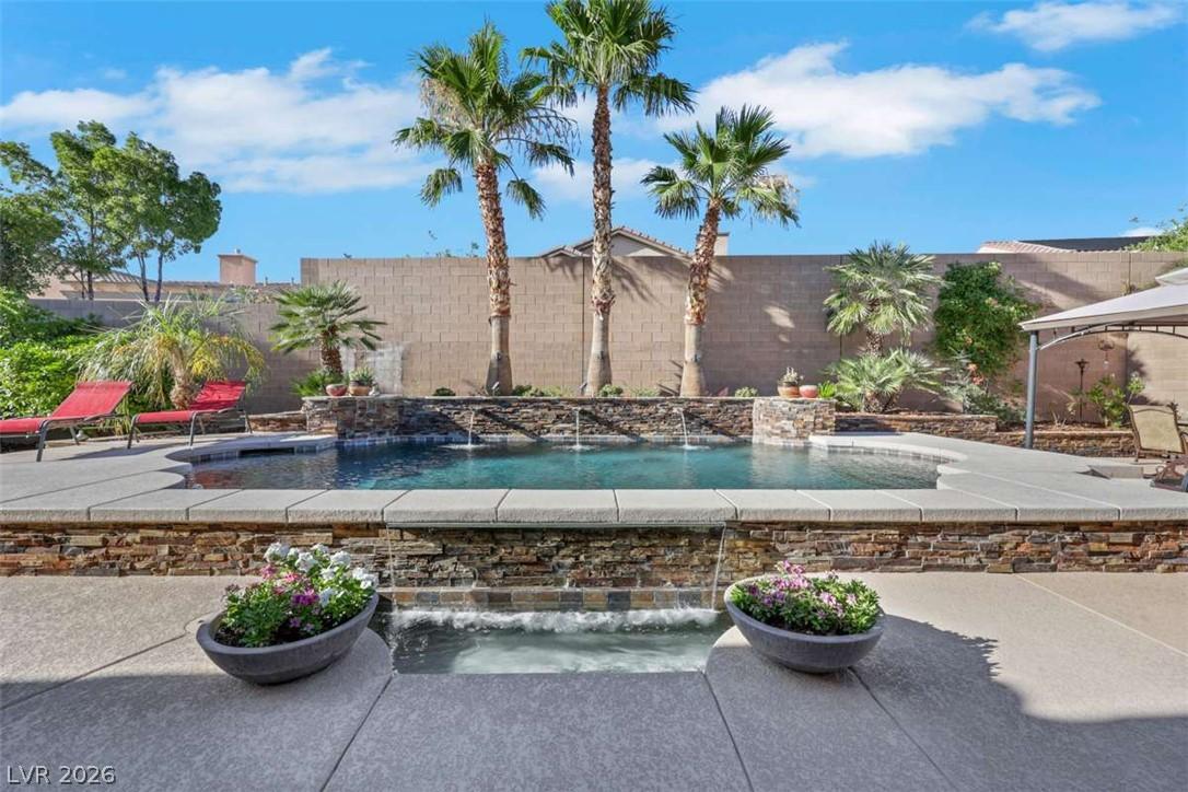 Image 2: Palm trees frame a shimmering pool with elegant wa