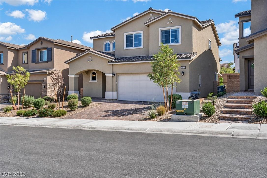 Image 4: A welcoming front exterior featuring a paver drive