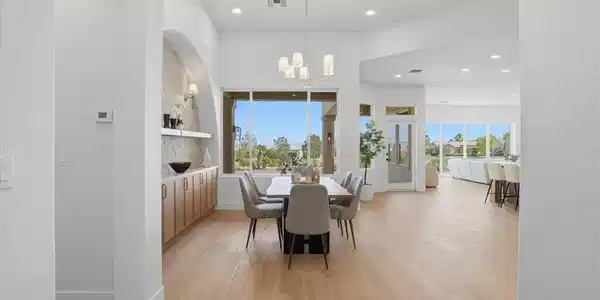Image 4: Gleaming hardwood floors and a lofty ceiling defin