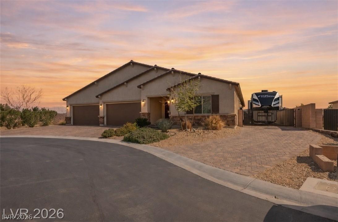 Image 1: A desert-modern residence features a paver drivewa