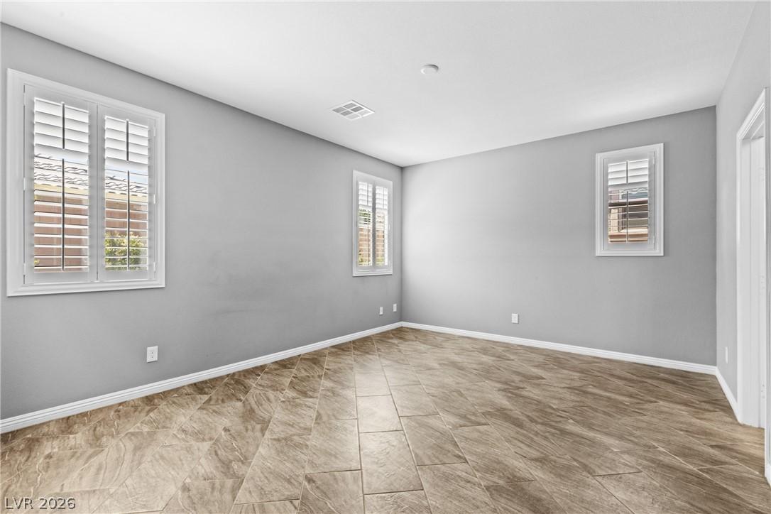 Image 3: Primary Bedroom with Tiled Floors and Plantation S