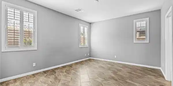 Image 3: Primary Bedroom with Tiled Floors and Plantation S