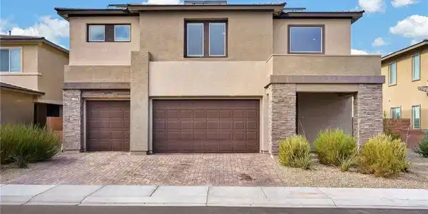 Image 3: A contemporary fa&ccedil;ade features a brick driveway an