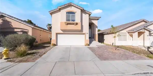 Image 2: A well-maintained stucco home with an attached gar