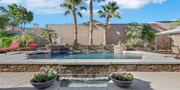 Image 2: Palm trees frame a shimmering pool with elegant wa