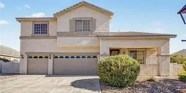 Image 2: A cream-colored stucco home presents a welcoming f