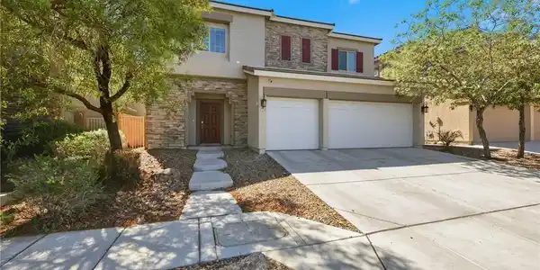 Image 2: Stone accents and a spacious concrete driveway hig
