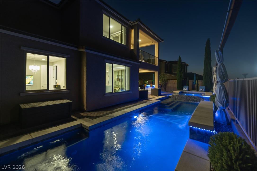 Image 3: An illuminated pool beckons beneath a night sky, o