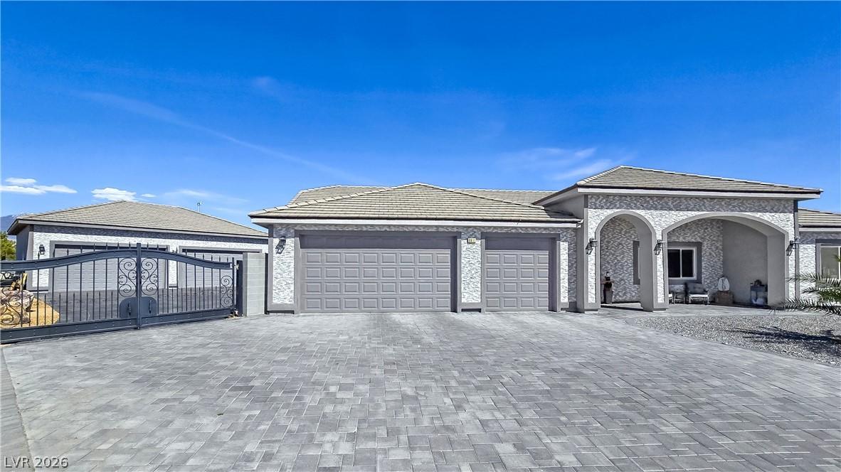 Image 3: A grand paved driveway leads to a three-car garage
